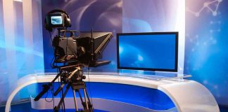 TV studio with camera and empty anchor desk
