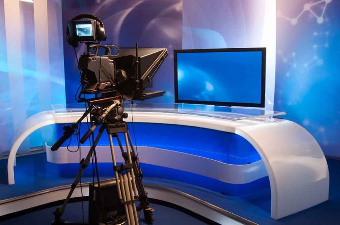 115378765 featured image TV studio with camera and empty anchor desk