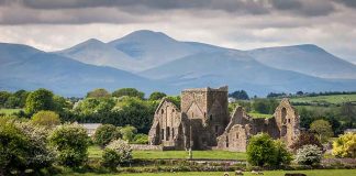 Ruins sheep grazing mountains and cloudy sky