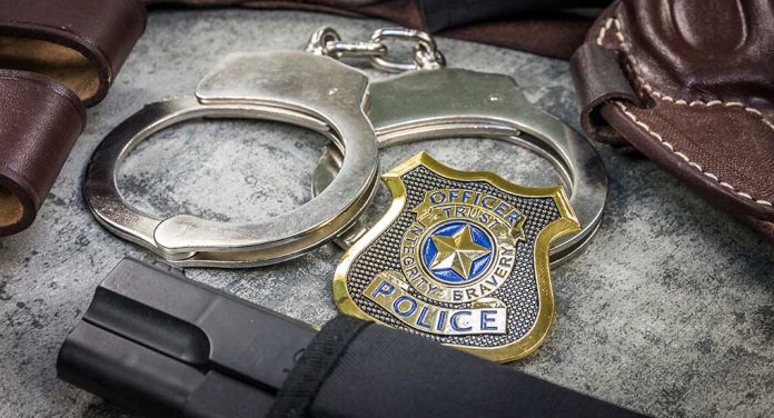 1939544200 featured image Handcuffs officer badge and firearm on textured surface