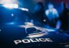 Police car with blurred figures in the background