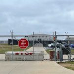 Chain link fence with Restricted Area Stop No Photography sign