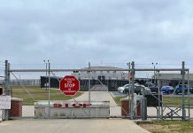 Chain link fence with Restricted Area Stop No Photography sign