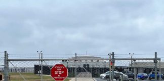 Chain link fence with Restricted Area Stop No Photography sign
