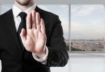 Person in suit with hand raised in stop gesture