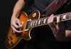 Hands playing an electric guitar