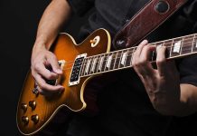 Hands playing an electric guitar