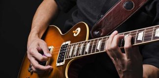 Hands playing an electric guitar