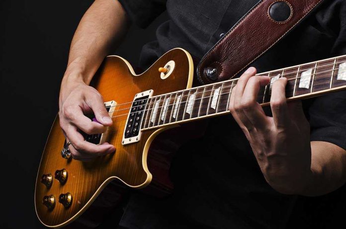 92514370 featured image Hands playing an electric guitar