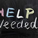 Help Needed written in colorful chalk