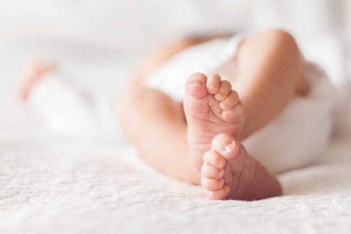 1111986902 Close-up of baby feet lying on blanket.