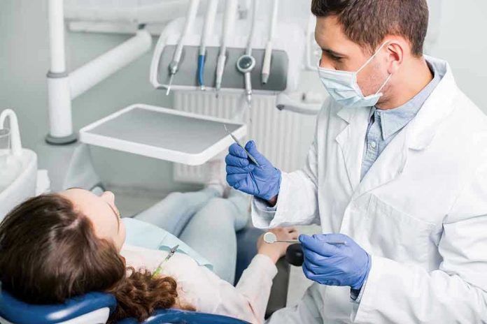 1317916853 Dentist examining a patient in a dental chair