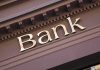 Gold bank sign on building facade