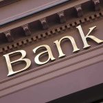 Gold bank sign on building facade