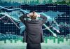 Person in front of falling stock market graph