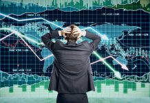 Person in front of falling stock market graph