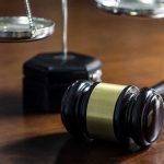 Gavel and scales of justice on wooden table
