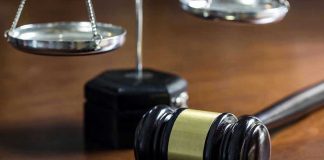 Gavel and scales of justice on wooden table
