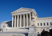 The Supreme Court building with large columns and a clear blue sky