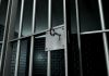 Close up of a locked prison gate with metal bars