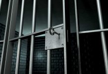 Close up of a locked prison gate with metal bars