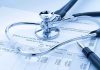 A stethoscope resting on a medical billing statement