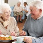 Elderly couple enjoying a meal together in a dining room