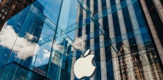 Apple store with glass facade and city reflections.