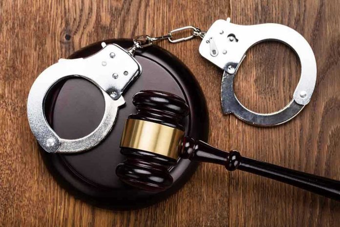 Gavel and handcuffs on wooden surface.