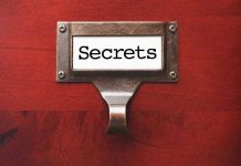 Tattoo Scandal Erupts—Maine Candidate Under Fire Metal label holder saying Secrets on wood background