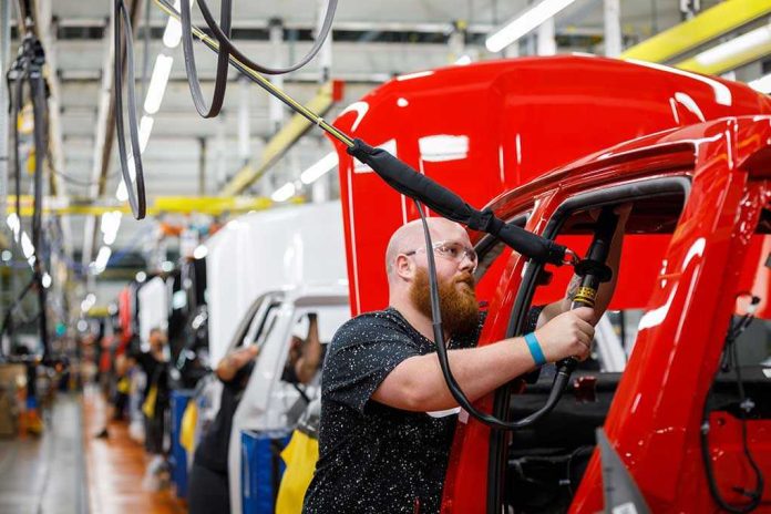 Worker assembling vehicles in a factory line.