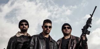 Three men in sunglasses holding guns, wearing black beanies.