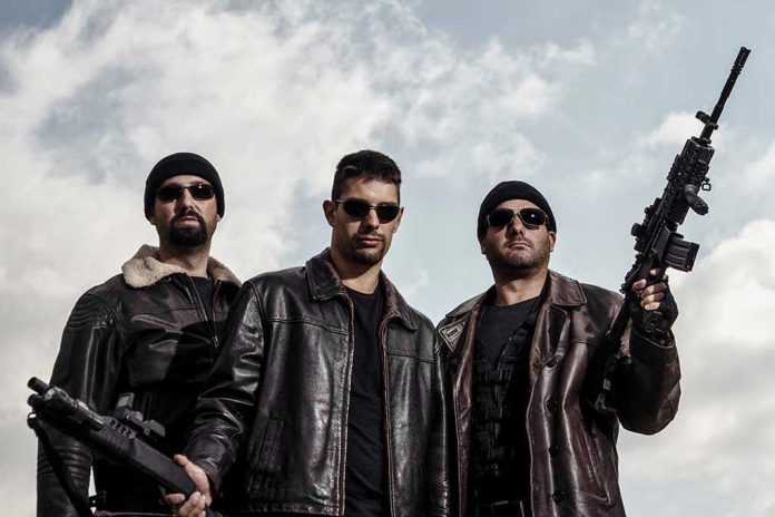 Three men in sunglasses holding guns, wearing black beanies.