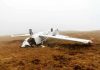 Crash Stuns Air Force — Converted Plane Fails Overturned crashed airplane on grassy field.