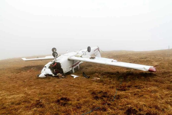 128891288 Overturned crashed airplane on grassy field.
