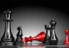 American Grandmaster Prodigy Dies at 29—Chess World Reeling Black and red chess pieces on a board.