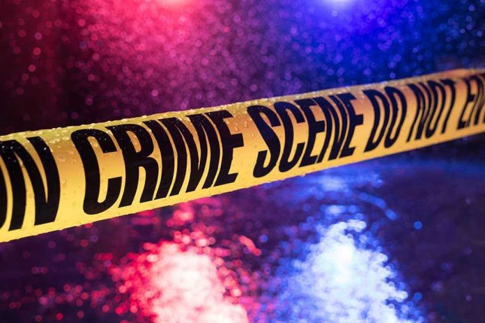 790342255 Yellow crime scene tape with police lights in background.