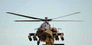 Military Apache helicopter flying in the sky