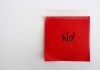 A red sticky note with the word No written in black ink
