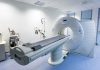Trump’s Mystery MRI — Health Transparency Demanded A CT scanner in a hospital room with medical equipment nearby