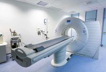 Trump’s Mystery MRI — Health Transparency Demanded A CT scanner in a hospital room with medical equipment nearby
