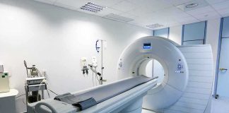 A CT scanner in a hospital room with medical equipment nearby