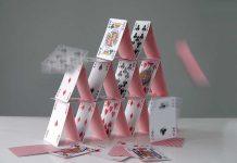A house of cards collapsing with some cards in motion