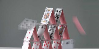 A house of cards collapsing with some cards in motion