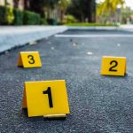 Sisters KILL Three Students — Racing Horror Crime scene markers on asphalt with bullet casing.