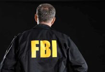 FBI Chief CAUGHT Red-Handed With Smoking Gun FBI agent with back facing the camera.