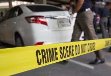 Massive Embezzlement Rocks German Town Crime scene tape blocking off white sedan.