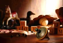 A wooden spinning top surrounded by vintage toys and colorful blocks