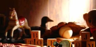 A wooden spinning top surrounded by vintage toys and colorful blocks