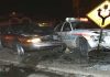 A damaged car and a police vehicle involved in a nighttime accident